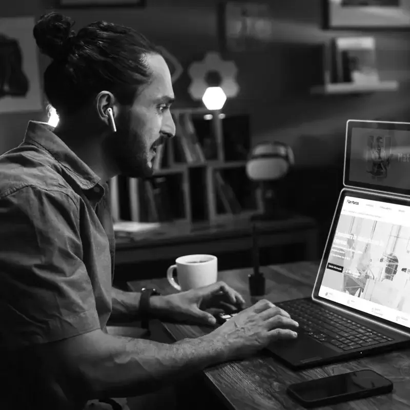 Un hombre de perfil sentado en un escritorio utilizando su computadora