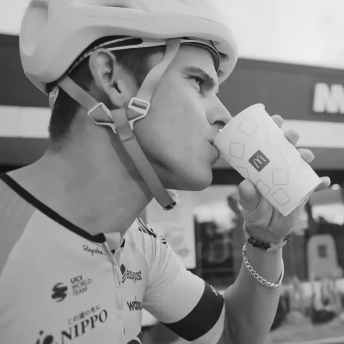 El ciclista profesional Andrey Amador, de perfil, bebiendo de un vaso con el logotipo de McDonalds